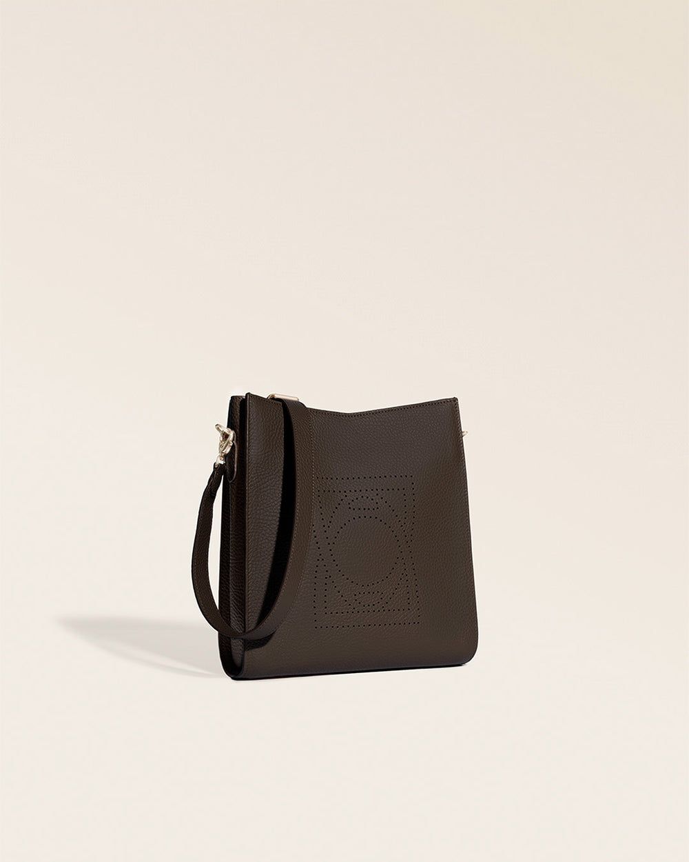 Le sac Mini Étrivière Renouard en cuir façon vigogne chocolat et bandoulière cuir, vu de quart en studio.