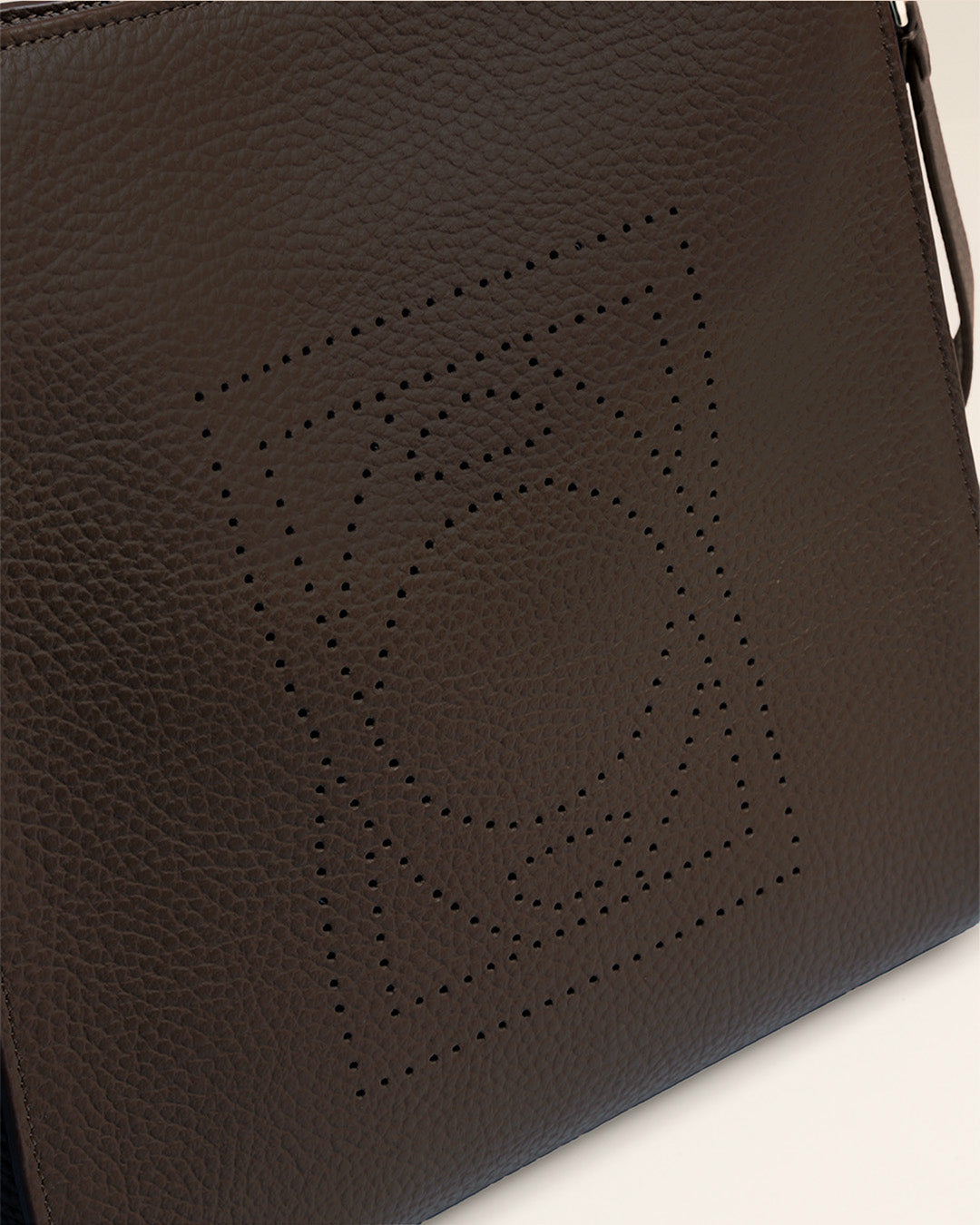 Le sac Mini Étrivière Renouard en cuir façon vigogne chocolat et bandoulière cuir, vu de près en studio.