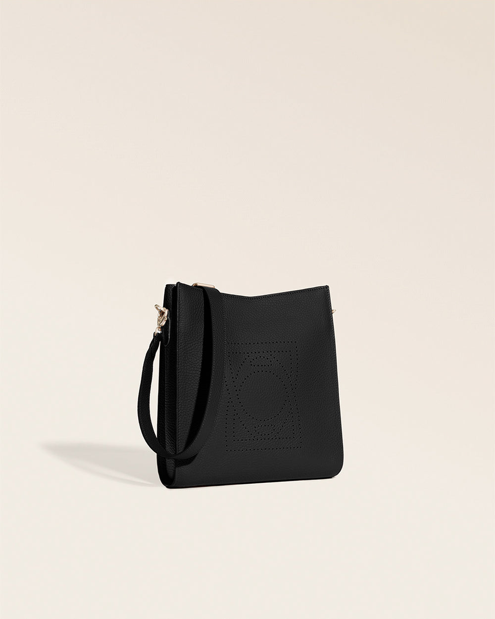 Le sac Mini Étrivière Renouard en cuir façon vigogne noir et bandoulière cuir, vu de quart en studio.