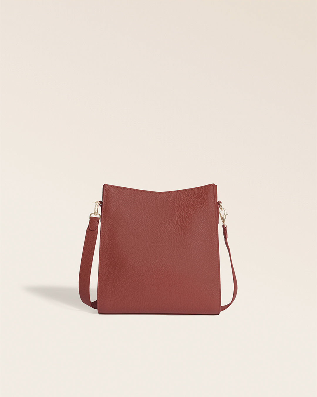 Le sac Mini Étrivière Renouard en cuir façon vigogne terracotta et bandoulière cuir, vu de dos en studio.