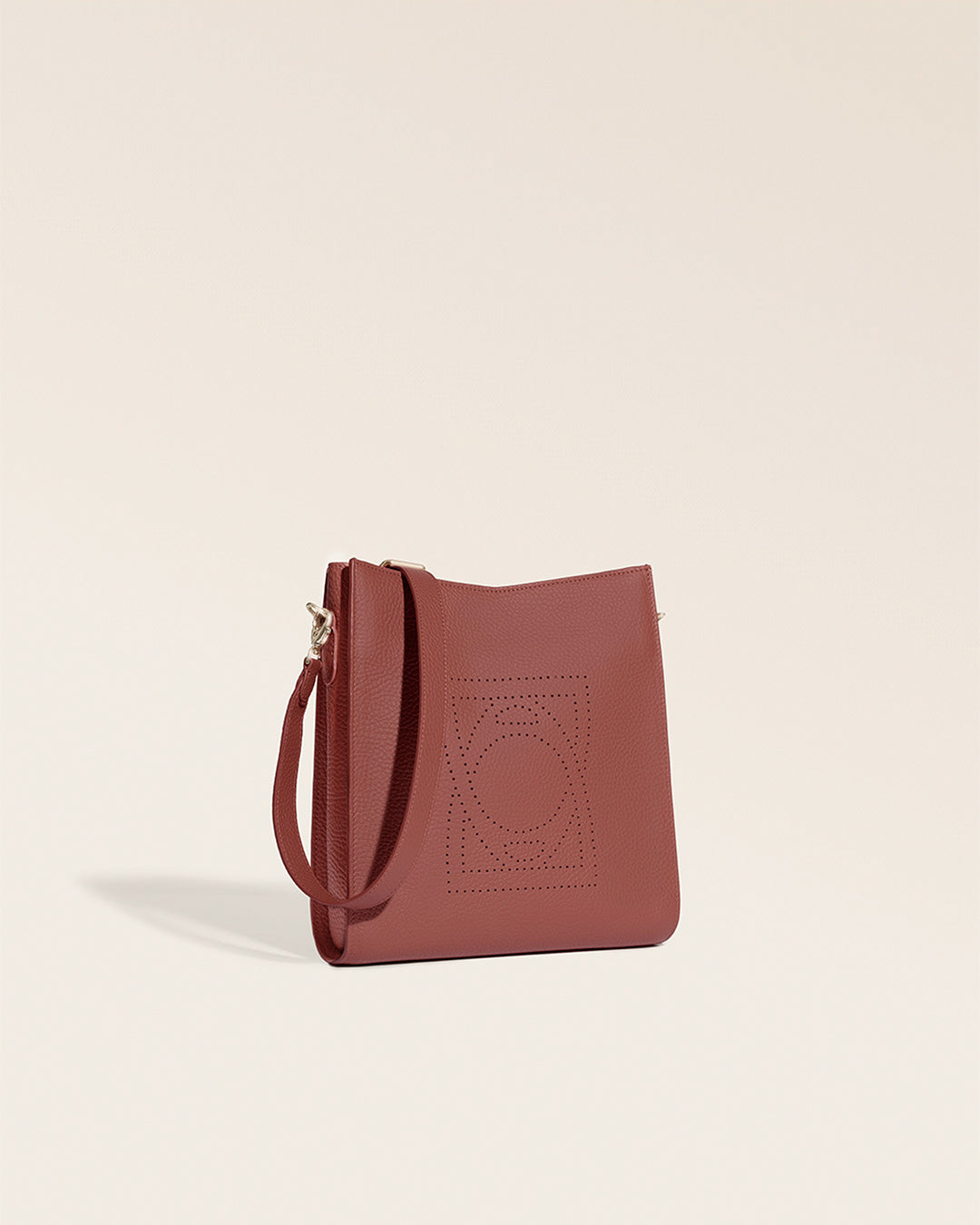 Le sac Mini Étrivière Renouard en cuir façon vigogne terracotta et bandoulière cuir, vu de quart en studio.