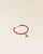 Notre bracelet Jumping en cuir d'agneau terracotta et pompon camel vu de quart en studio.
