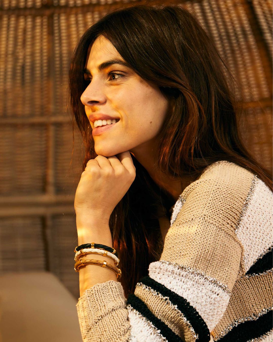 Nos bracelets Lisbonne en cuir d'agneau tressé camel, noir et craie vus portés en accumulation par notre mannequin. 