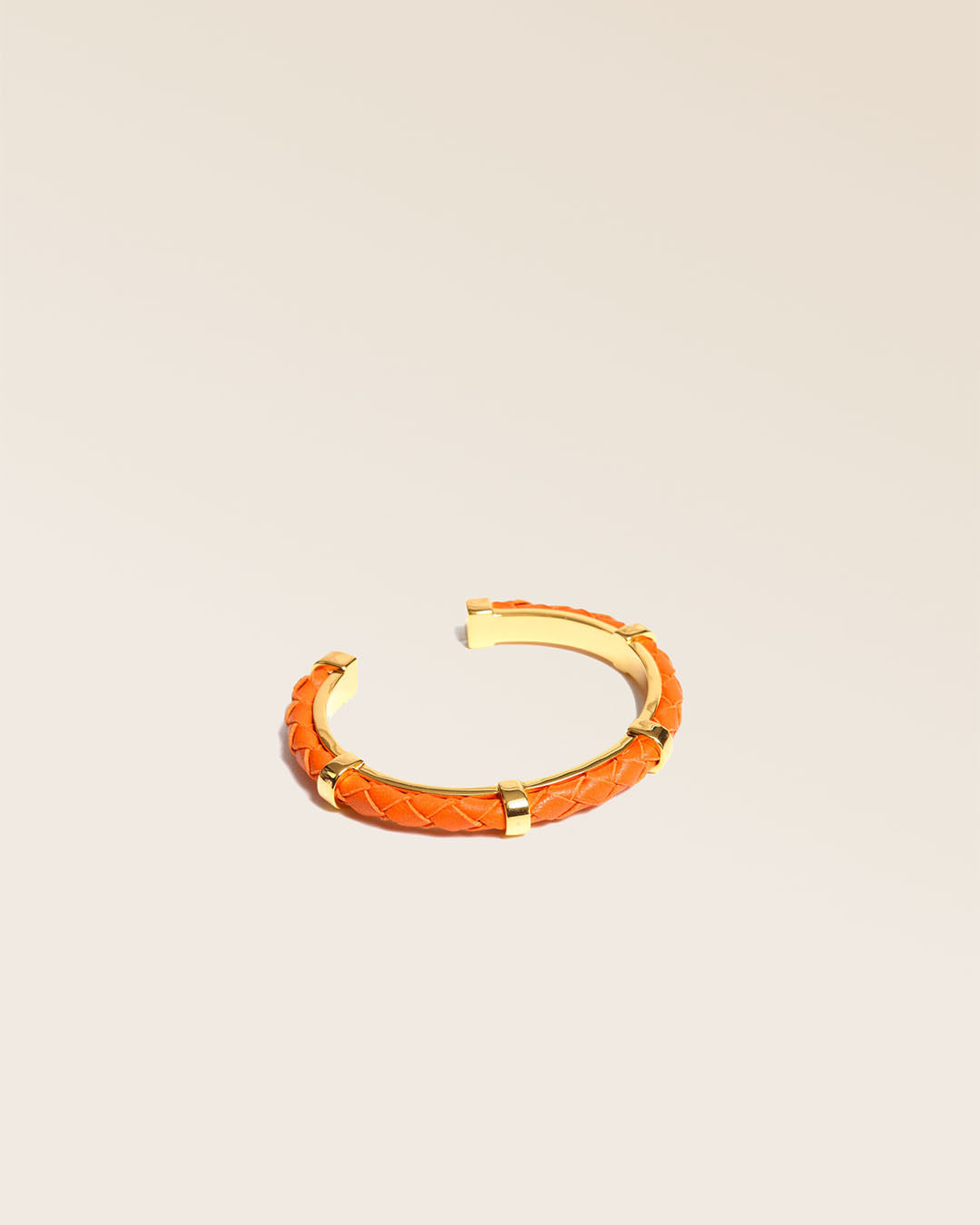 Notre bracelet Lisbonne en cuir d'agneau tressé orange vu de quart en studio.