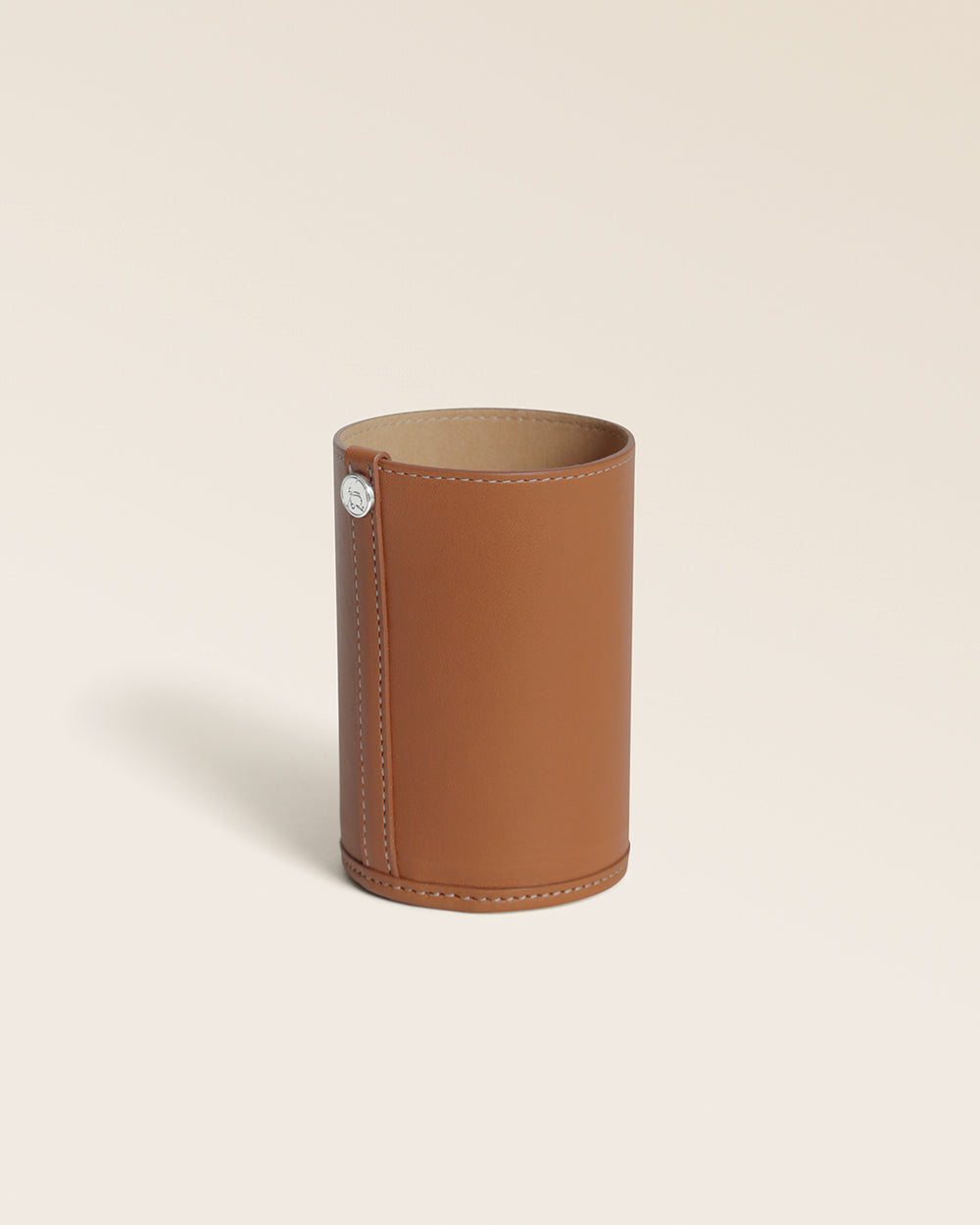 Notre pot à crayons Renouard en cuir vintage camel, vu de quart en studio.
