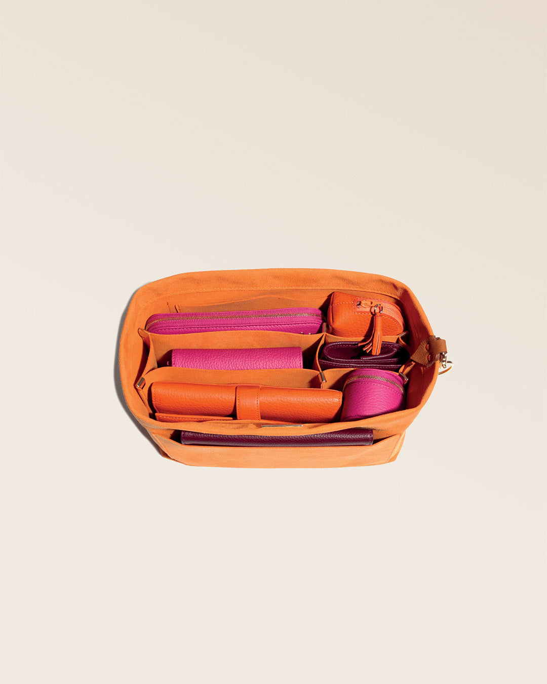 Notre organisateur de sac en toile suédine orange vu accessoirisé en studio.