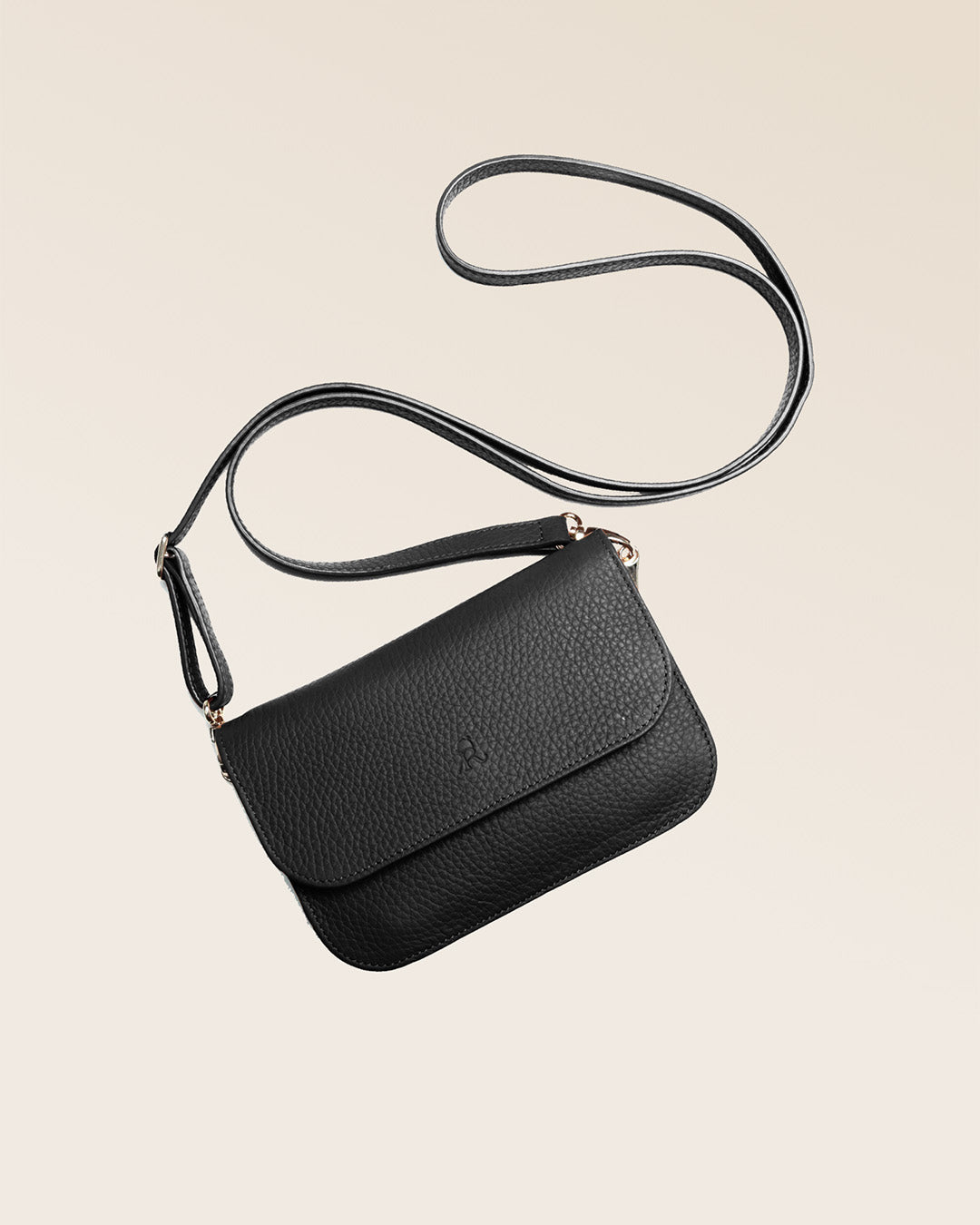 Notre pochette Coralie en cuir façon vigogne noir vue à plat  en studio.