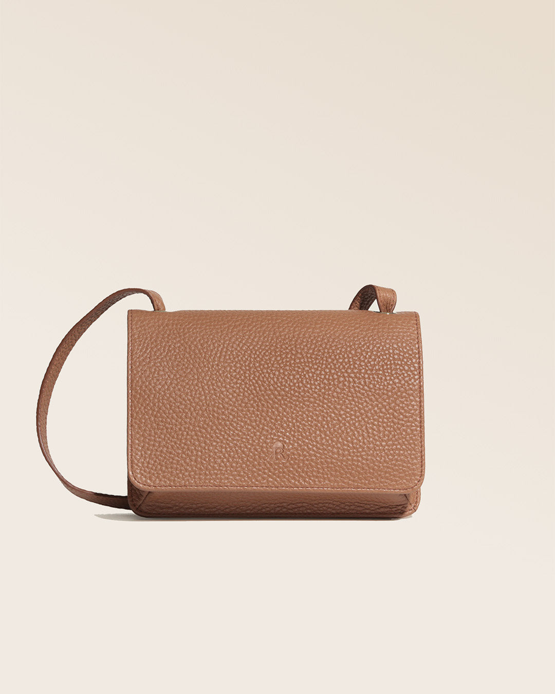 Notre pochette Fréhel en cuir façon vigogne fauve vue de face en studio.