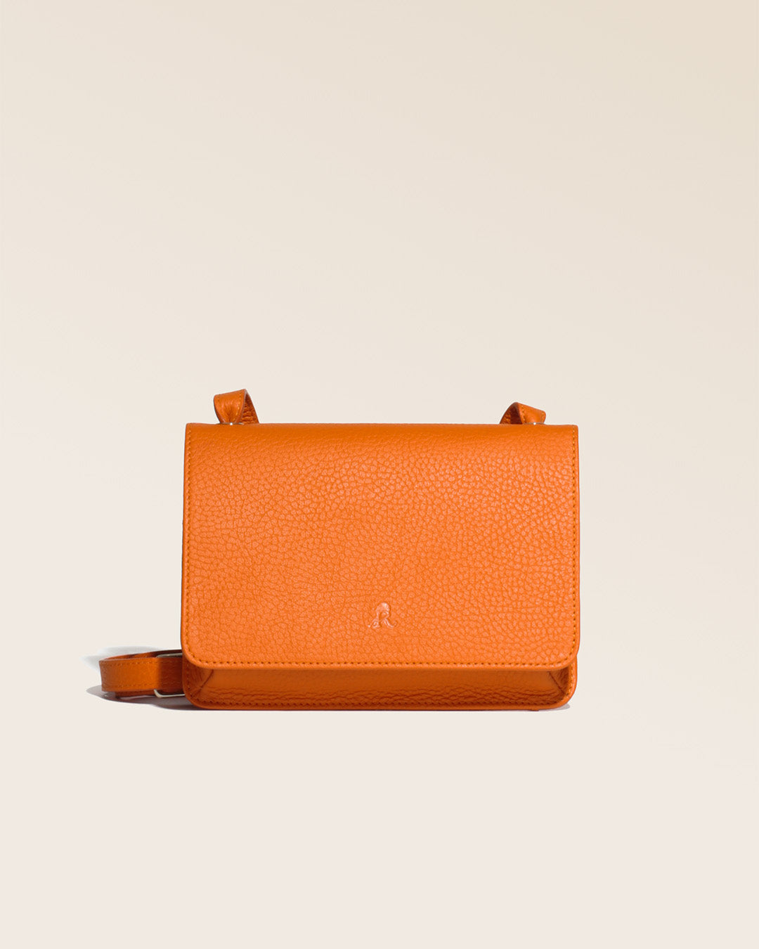 Notre pochette Fréhel en cuir façon vigogne orange vue de face en studio.