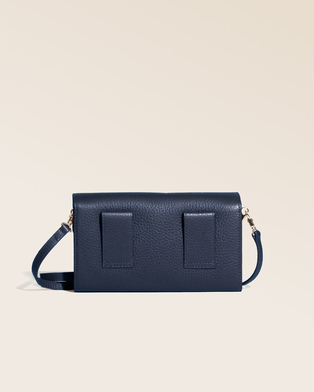 Notre pochette Raphaël en cuir façon vigogne bleu marine vue de dos en studio.