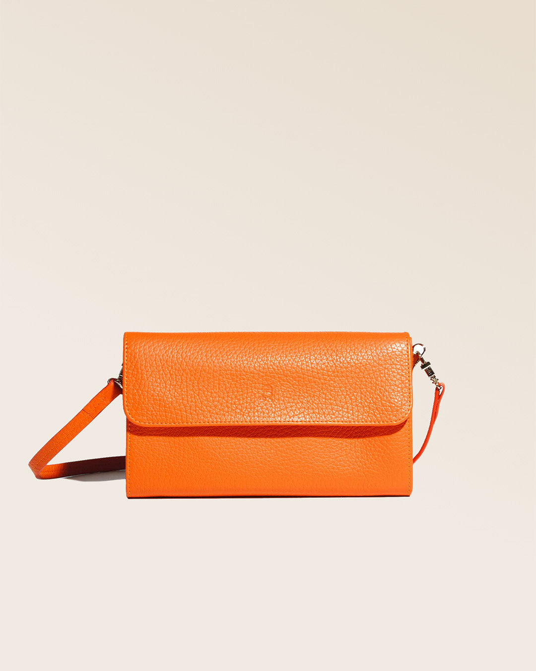 Notre pochette Raphaël en cuir façon vigogne orange vue de face en studio.