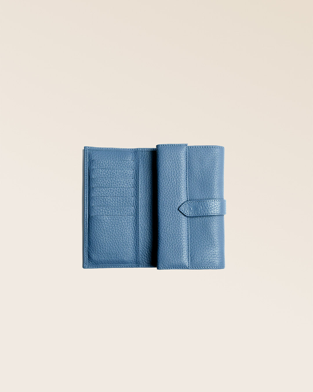 Notre porte-monnaie Adèle en cuir façon vigogne bleu cobalt vu ouvert en studio.