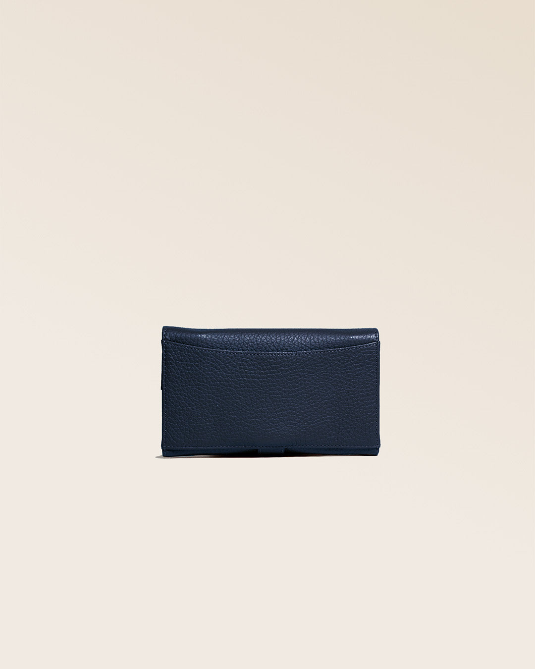 Notre porte-monnaie Adèle en cuir façon vigogne bleu marine vu de dos en studio.