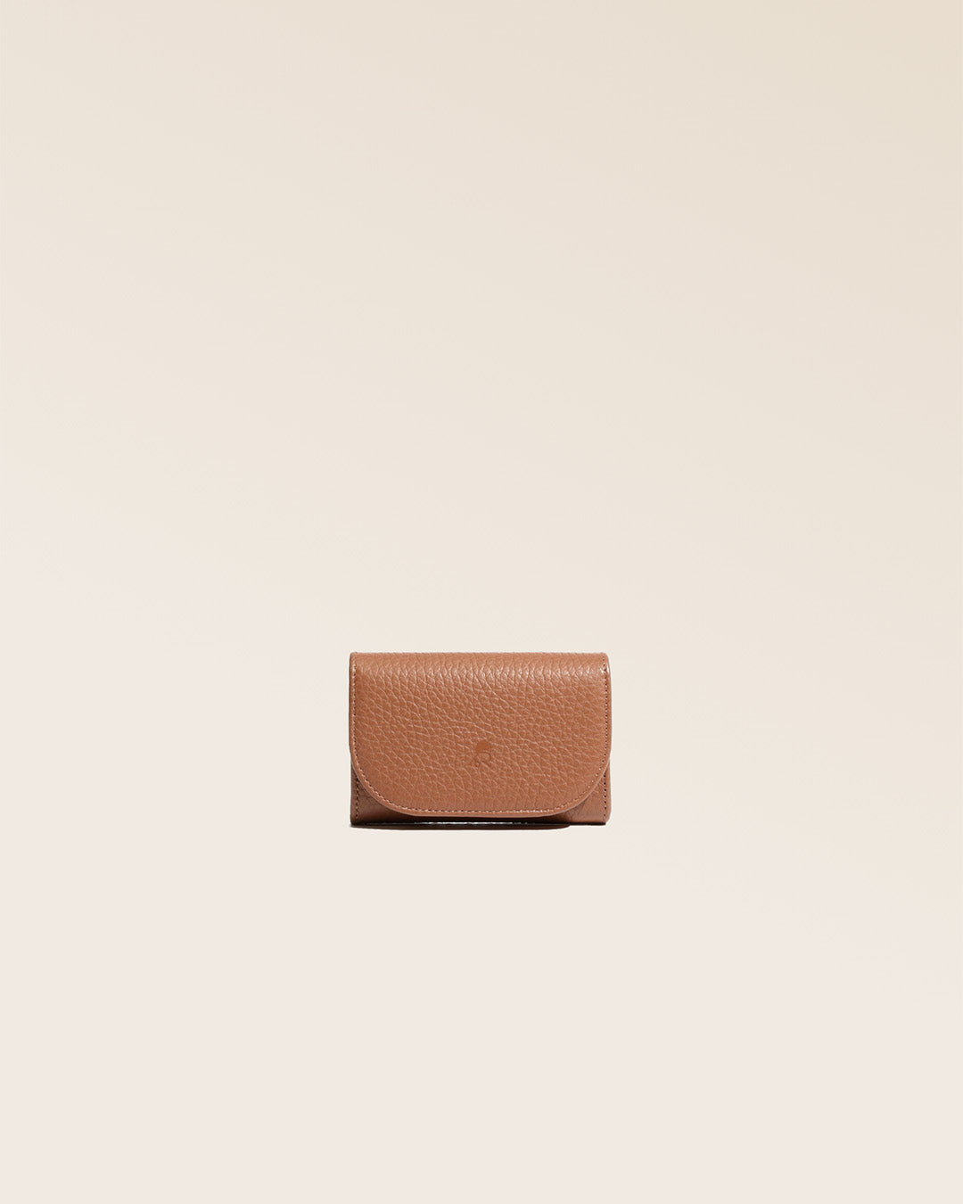 Notre porte-monnaie Alma en cuir façon vigogne fauve vu de face en studio.