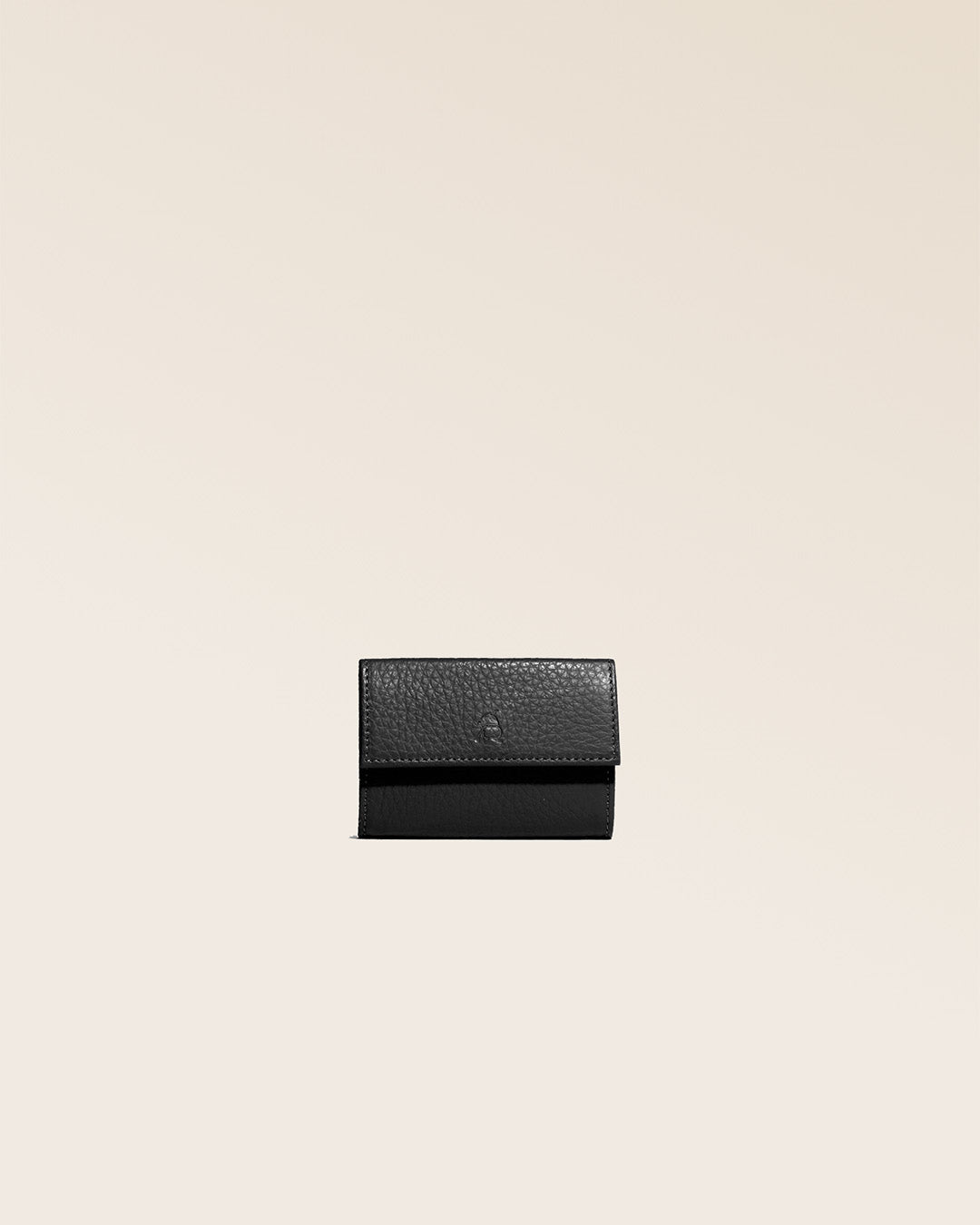 Notre porte-monnaie Mixte en cuir façon vigogne noir vu de face en studio.