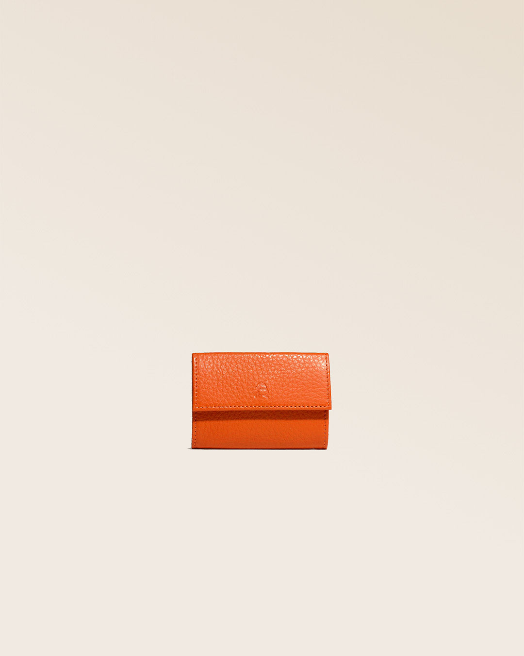 Notre porte-monnaie Mixte en cuir façon vigogne orange vu de face en studio.