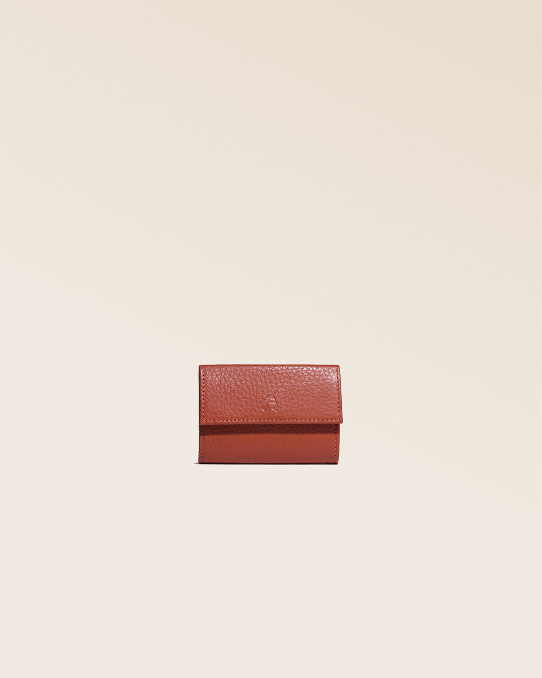 Notre porte-monnaie Mixte en cuir façon vigogne terracotta vu de face en studio.