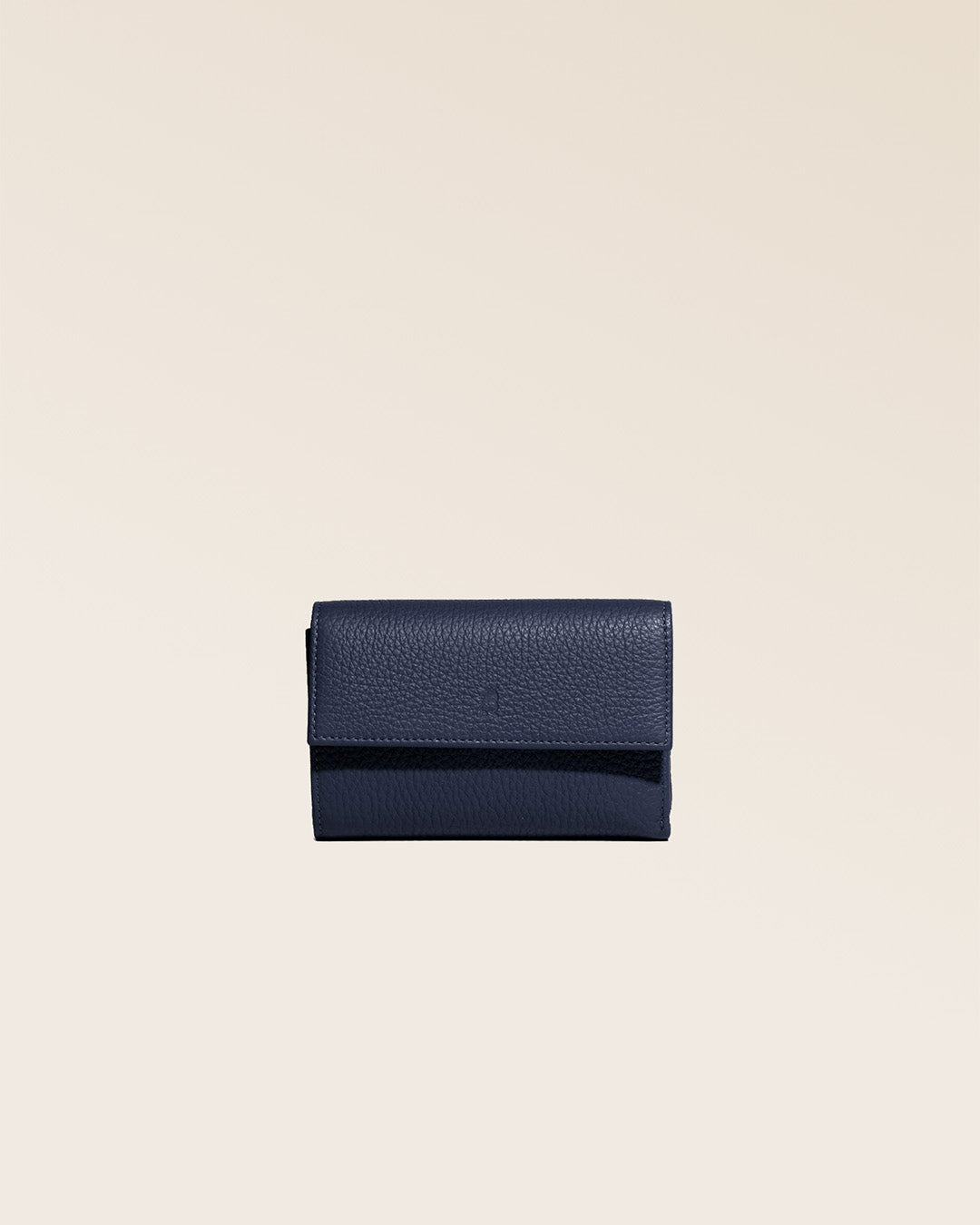 Notre porte-monnaie Opale en cuir façn vigogne bleu marine vu de face en studio.