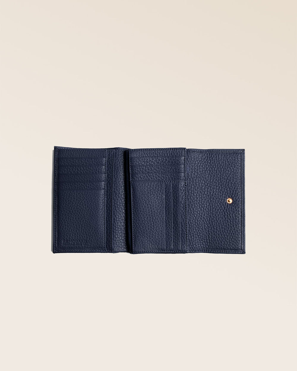 Notre porte-monnaie Opale en cuir façn vigogne bleu marine vu ouvert en studio.