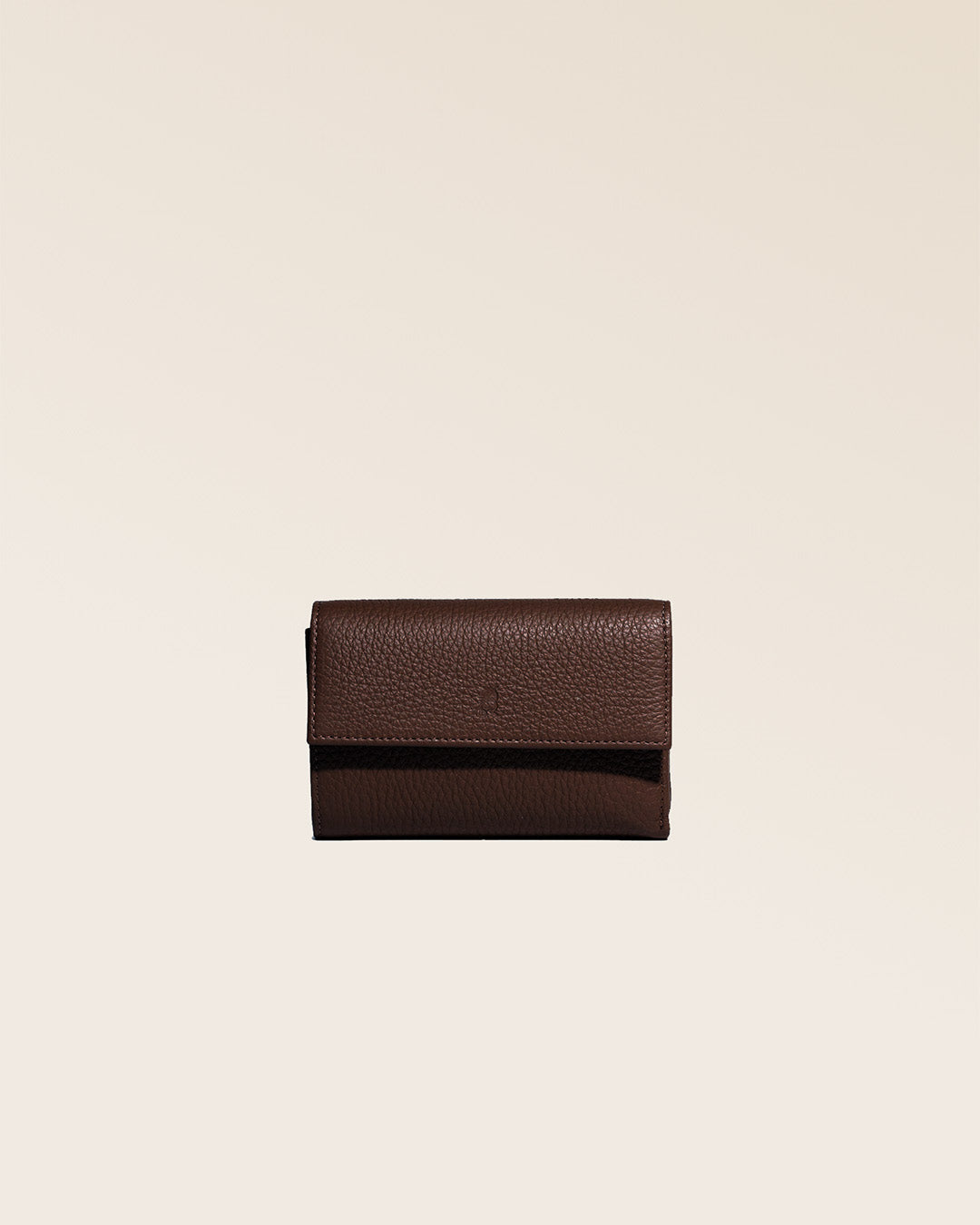 Notre porte-monnaie Opale Renouard en cuir façon vigogne chocolat, vu de face fermé en studio.