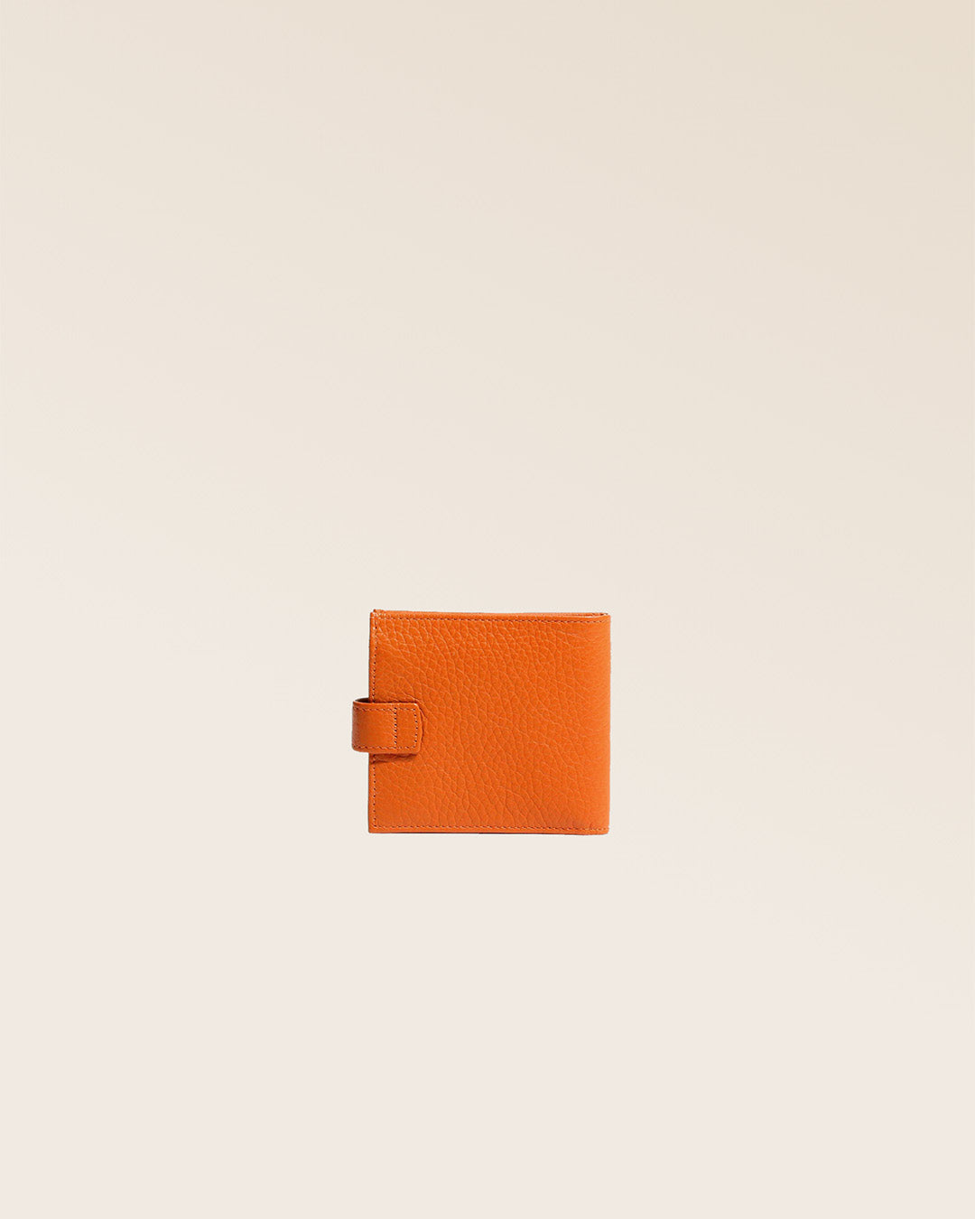 Notre porte-monnaie Rabat en cuir façon vigogne orange vu de dos en studio.