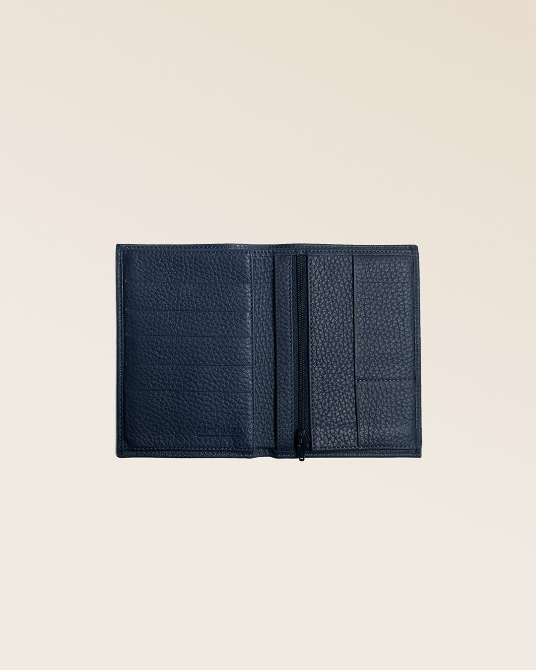 Notre portefeuille Papiers en cuir façon vigogne bleu marine vu ouvert partiellement en studio.