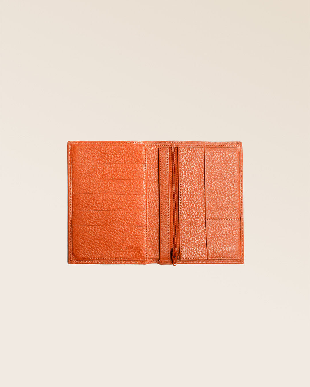 Notre portefeuille Papiers en cuir façon vigogne orange vu ouvert partiellement en studio.