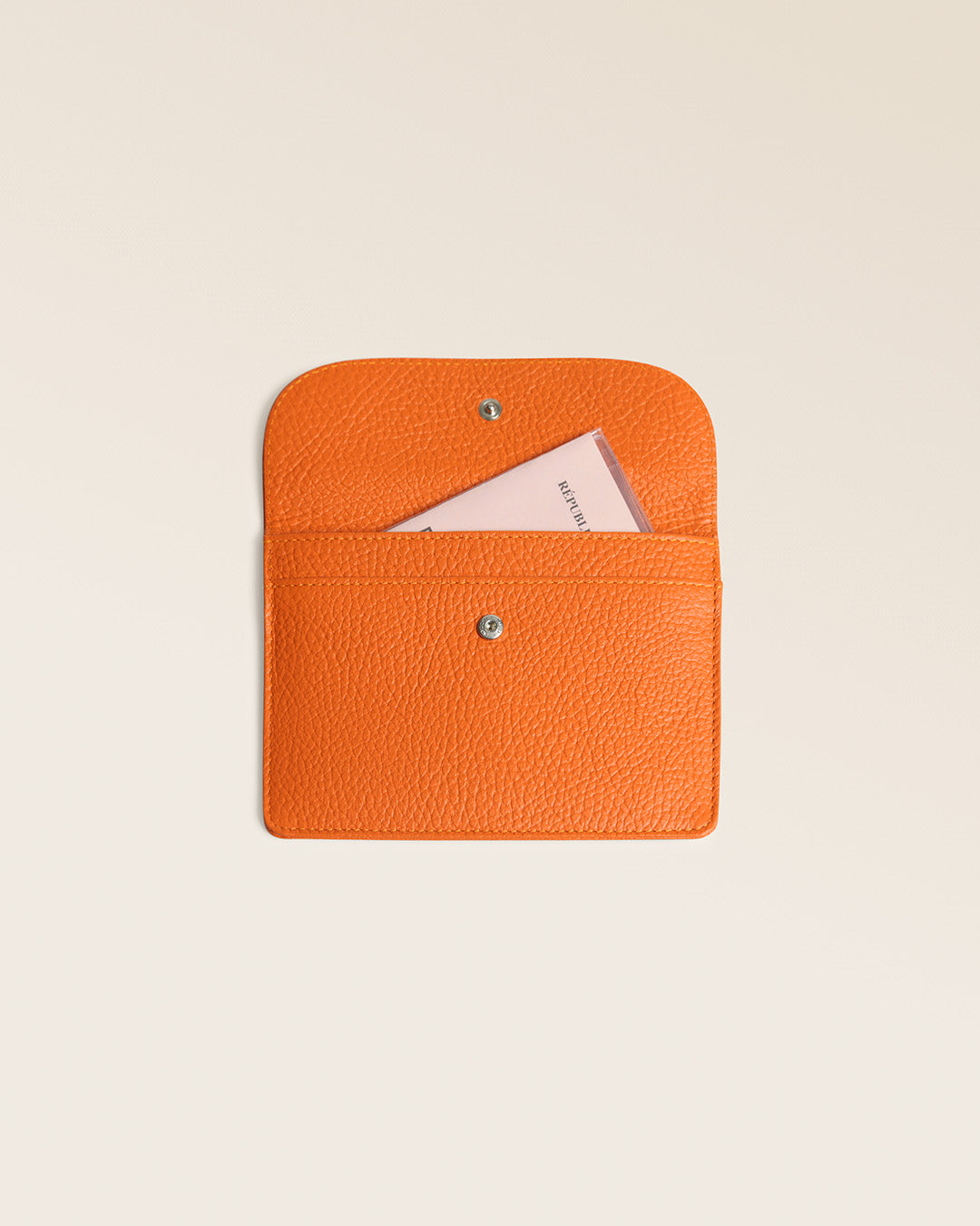 Notre porte-papiers Aurore Renouard en cuir façon vigogne orange, vu de face ouvert en studio.