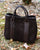 Le sac cabas Max Renouard en cuir veau velours espresso et lisse ébène, vu de face en ambiance. 