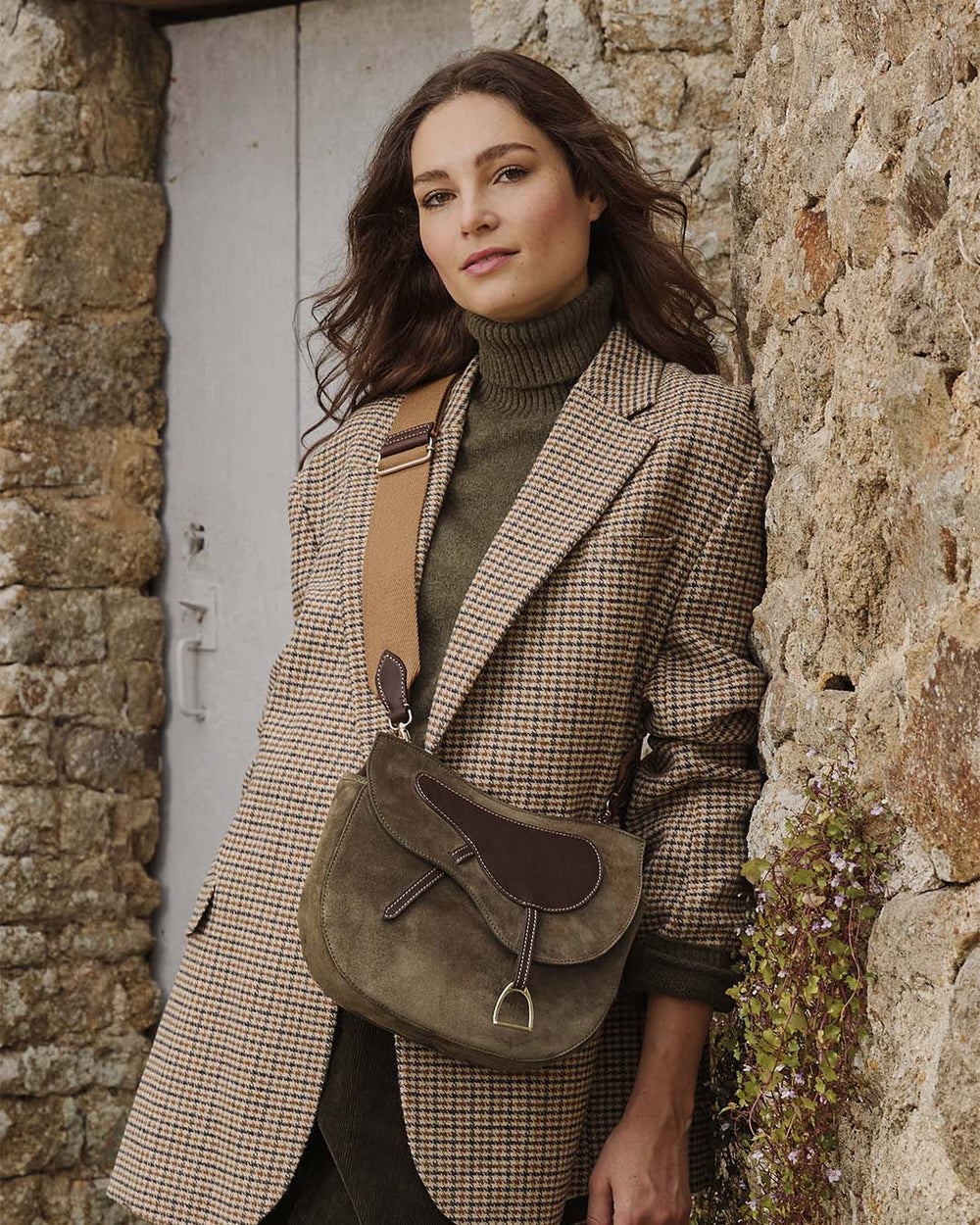 Notre sac Cavalerie Renouard en cuir veau velours truffe avec sa bandoulière en coton, vu porté par notre mannequin. 
