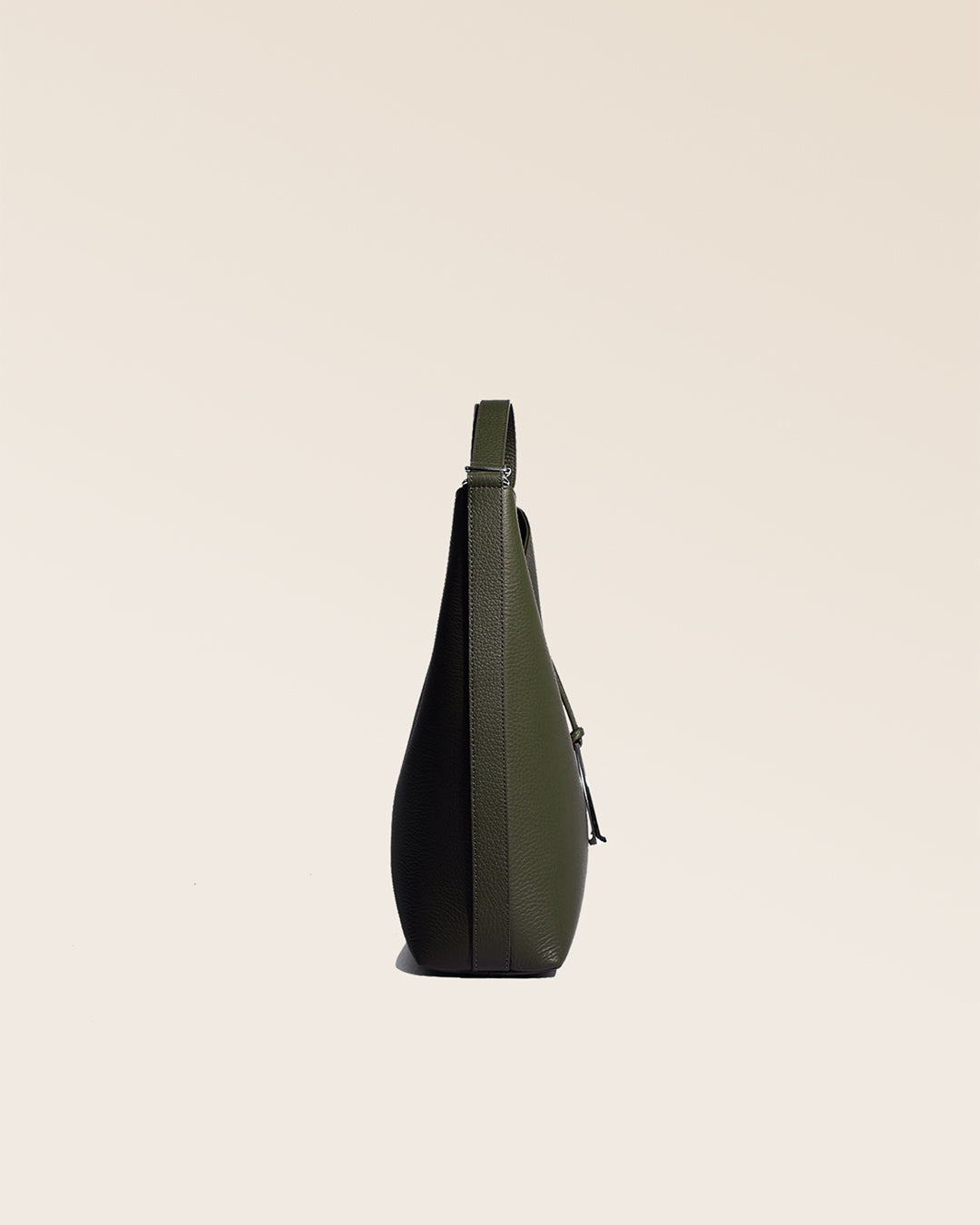 Notre sac Cob Renouard, dans sa version grand modèle, en cuir façon vigogne kaki, vu de côté en studio.