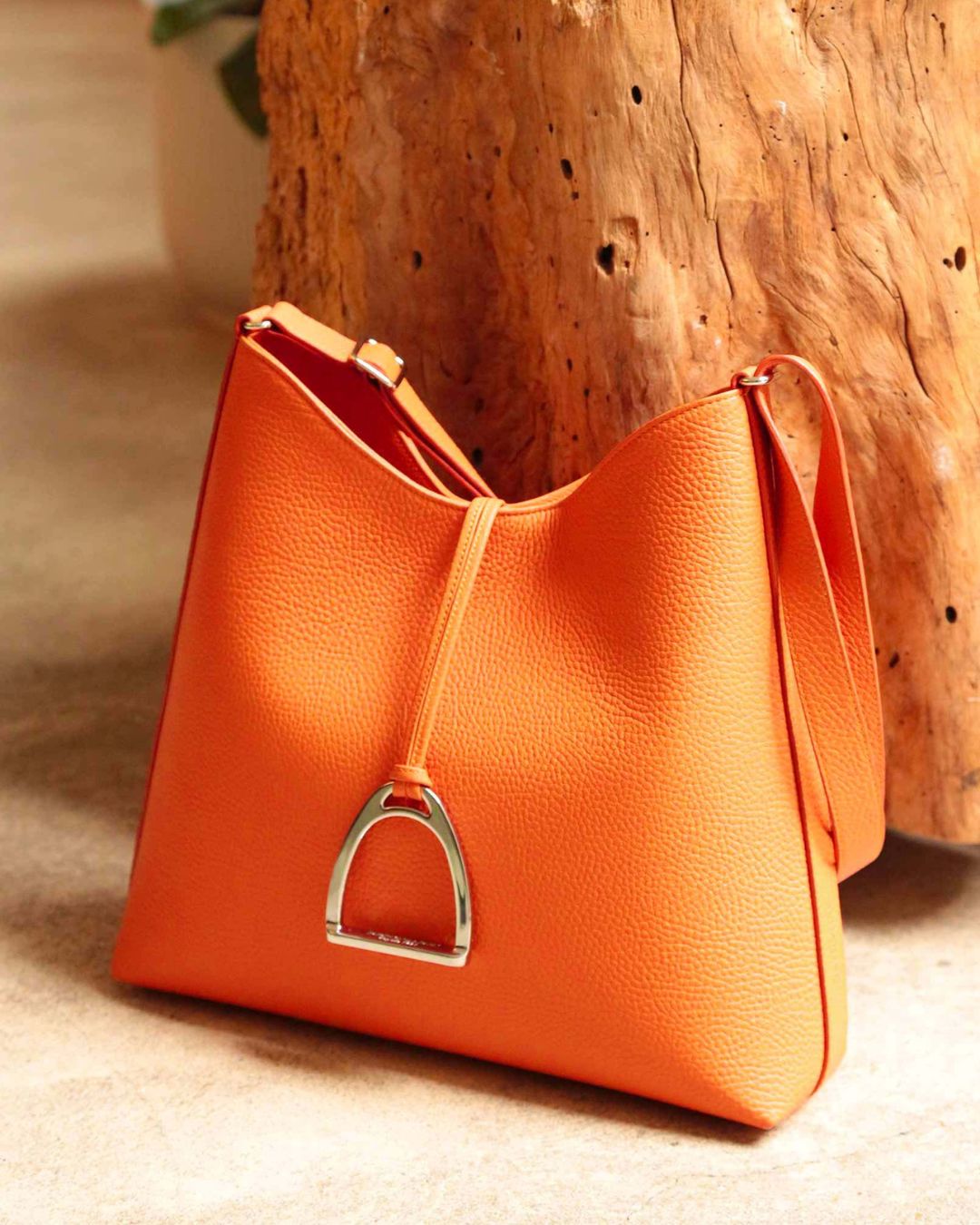 Le sac Cob Renouard en cuir façon vigogne orange, vu de quart en ambiance.
