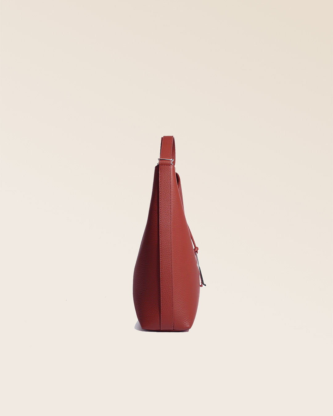 Notre sac Cob Renouard, dans sa version grand modèle, en cuir façon vigogne terracotta, vu de côté en studio.