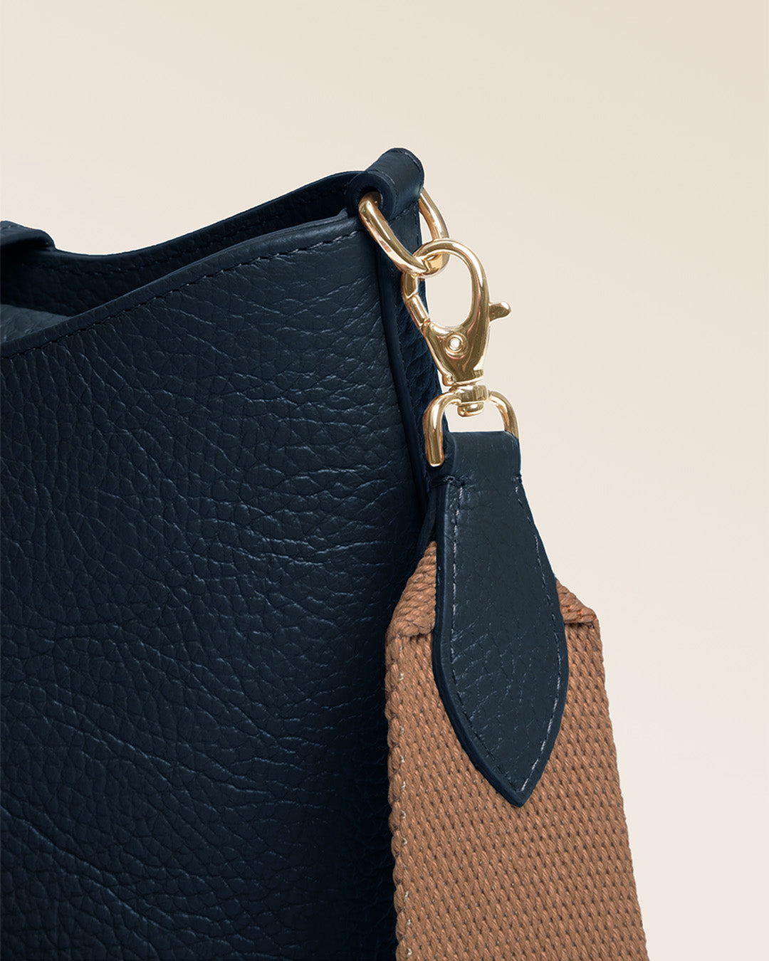 Notre sac Cob Renouard dans sa version Mini modèle, cuir façon vigogne bleu marine et bandoulière coton ; vu de près en studio.