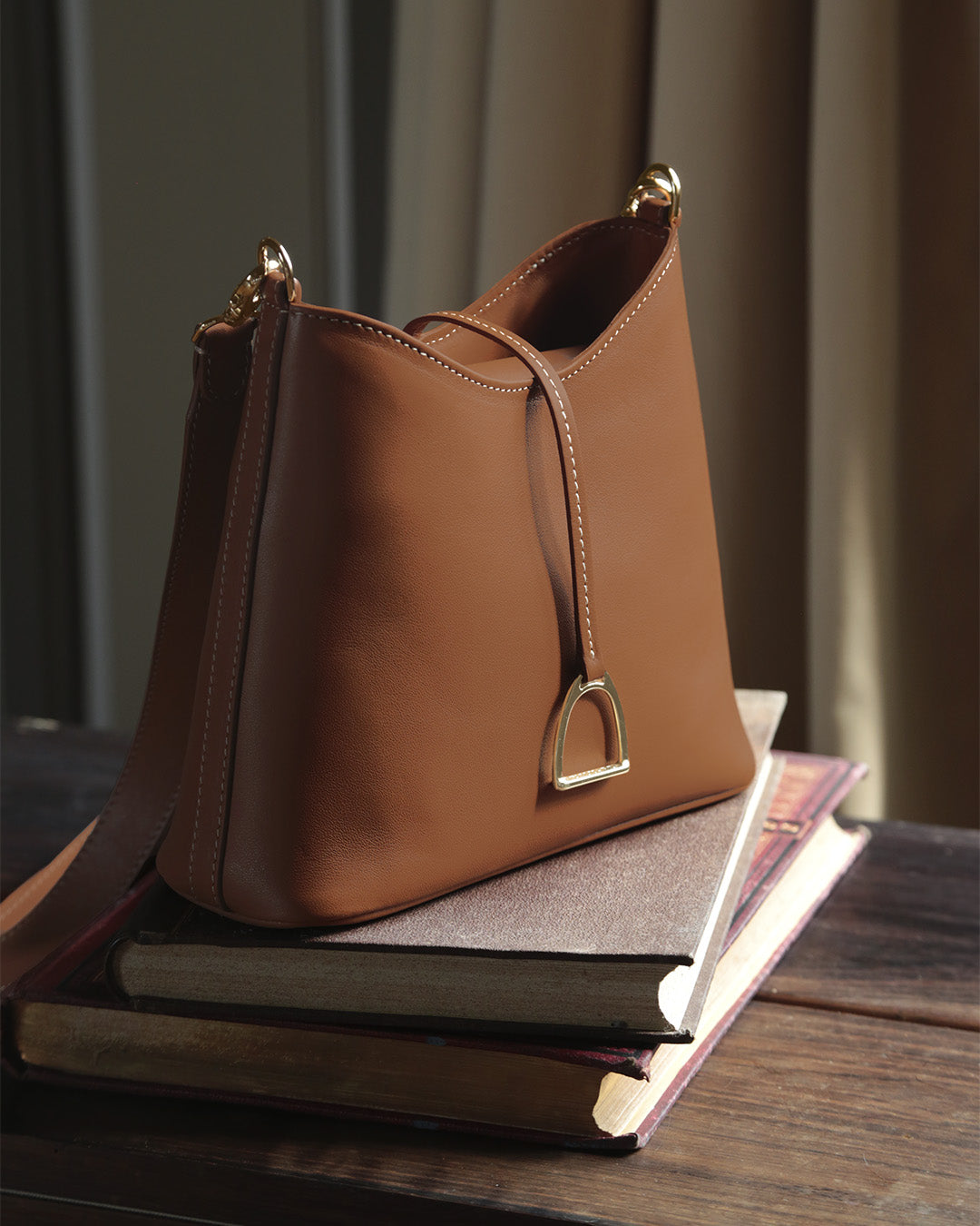 Notre sac Cob Renouard dans sa version Mini modèle, en cuir vintage camel et bandoulière cuir ; vu de quart en ambiance.