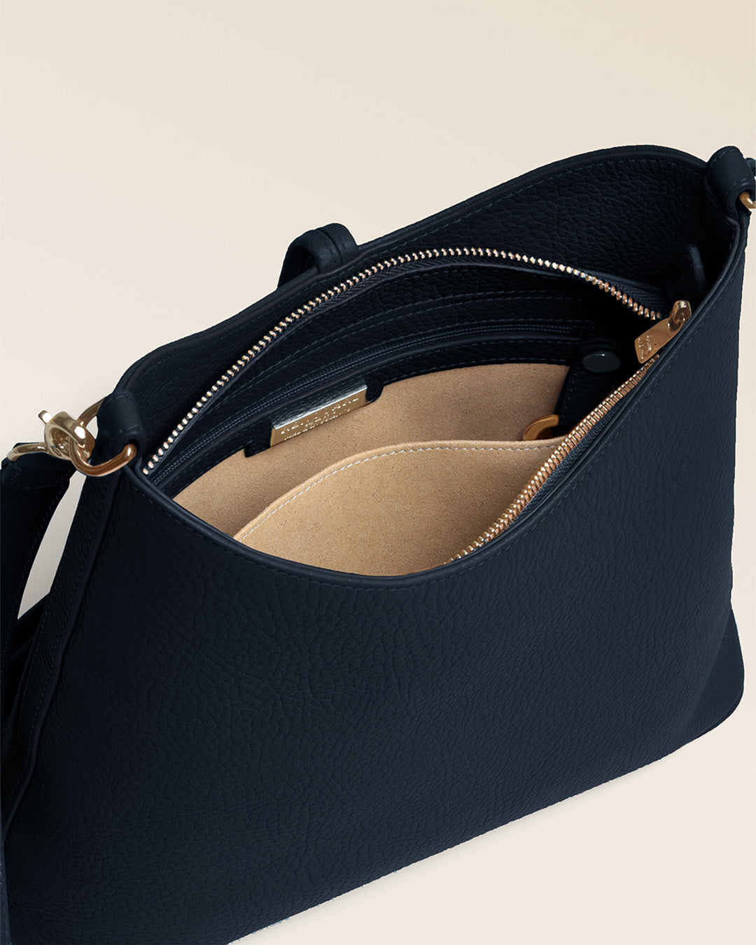 Notre sac Petit Cob Renouard en cuir façon vigogne bleu marine, accessoires dorés et bandoulière cuir ; vu du dessus en studio. #bandoulière_cuir