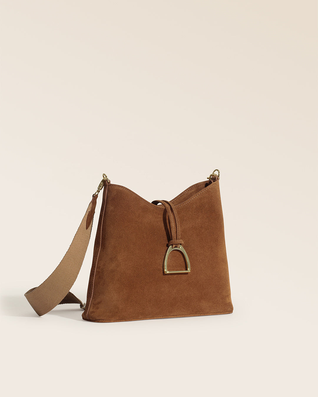 Notre sac Cob Renouard dans sa version petit modèle, cuir veau velours noisette et bandoulière coton camel ; vu de quart en studio.