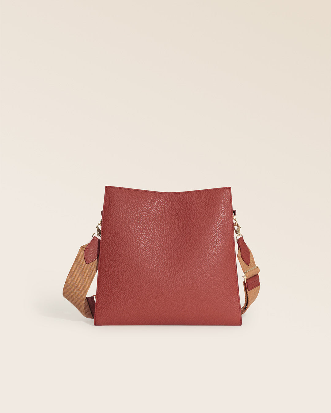 Notre sac Étrivière Renouard en cuir façon vigogne terracotta et bandoulière coton camel, vu de dos en studio.