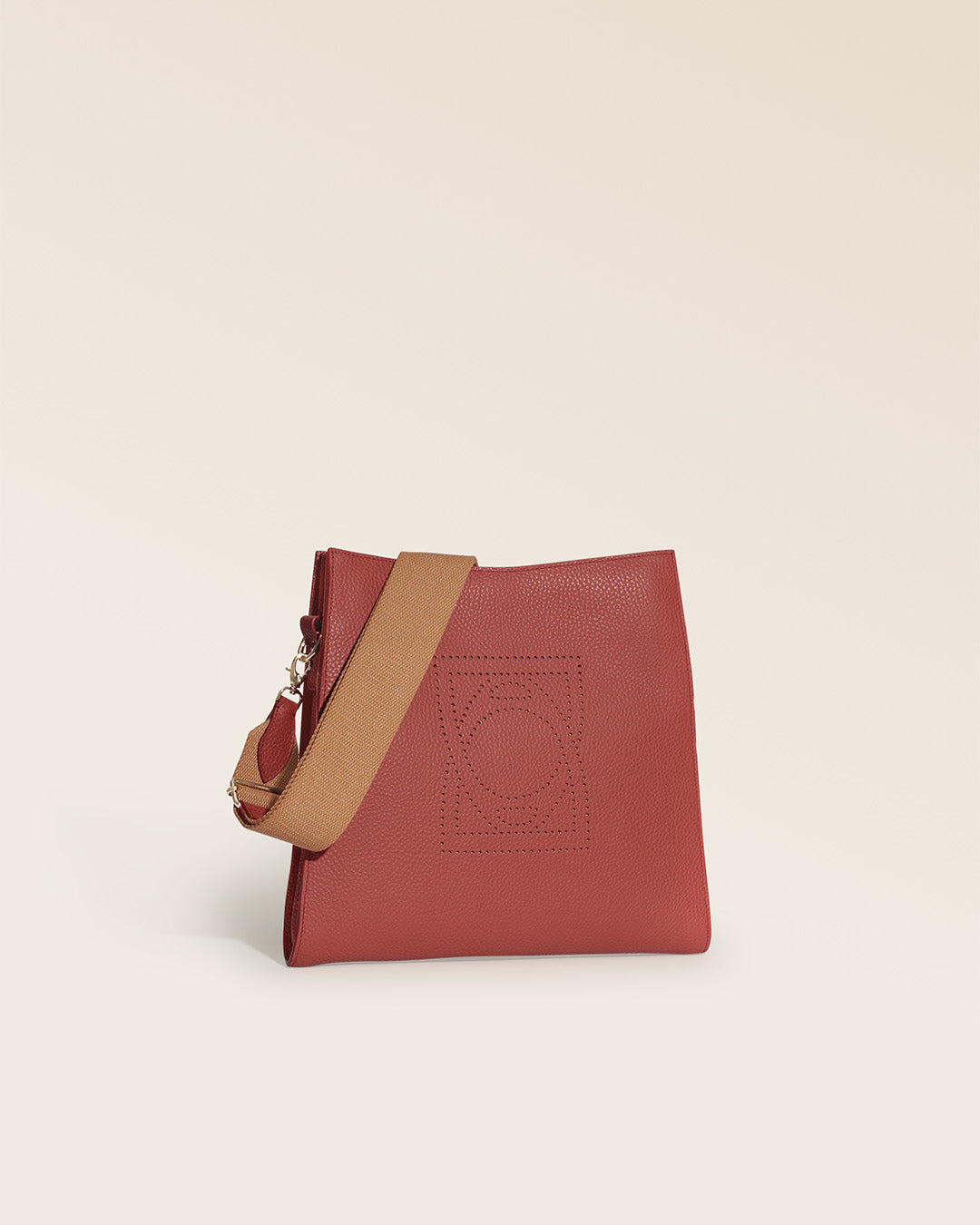 Notre sac Étrivière Renouard en cuir façon vigogne terracotta et bandoulière coton camel, vu de quart en studio.