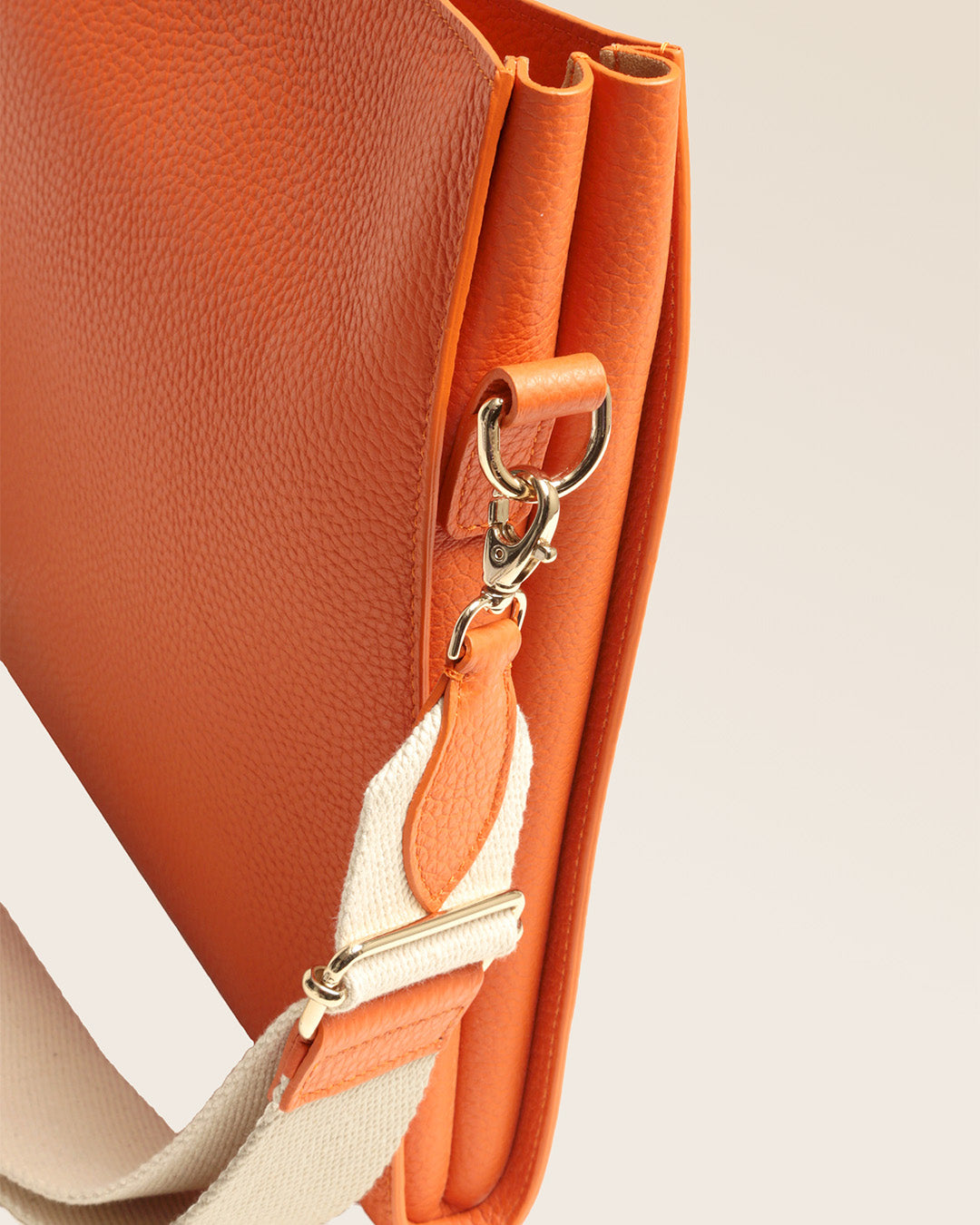 Notre sac Étrivière petit modèle en cuir façon vigogne orange vu en détail en studio.