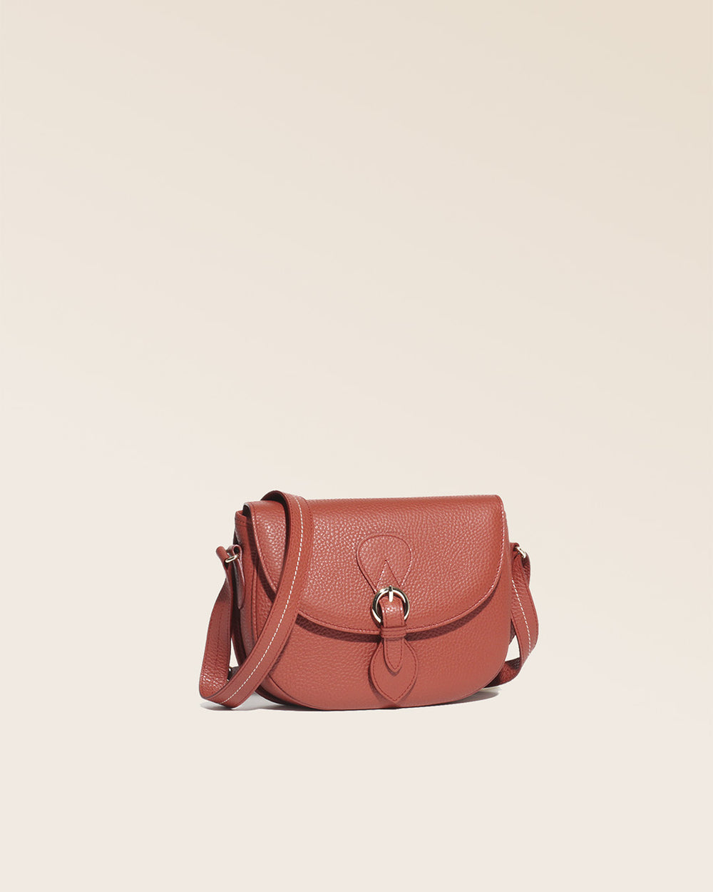 Notre sac gibecière Léa en cuir façon vigogne terracotta vu de quart en studio.