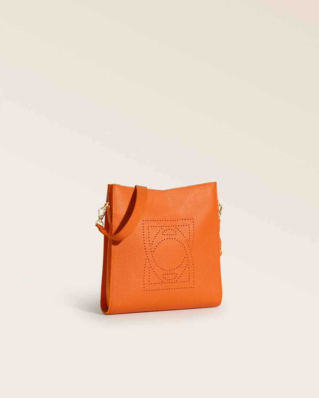 Notre sac Mini Étrivière Renouard en cuir façon vigogne orange vu de quart en studio.