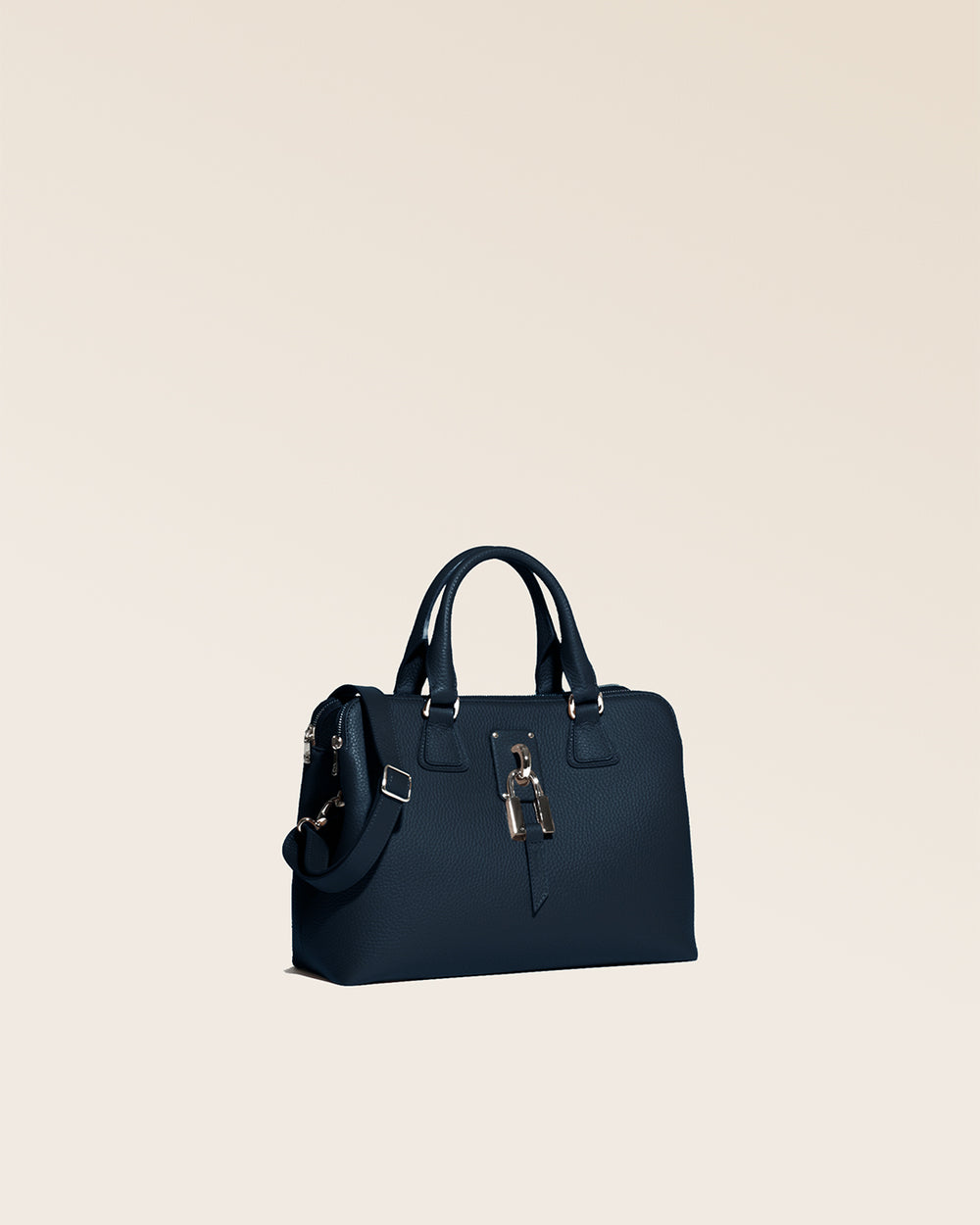 Notre sac New-York Renouard, dans sa version Mini, en cuir façon vigogne bleu marine et accessoires dorés, vu de quart en studio.