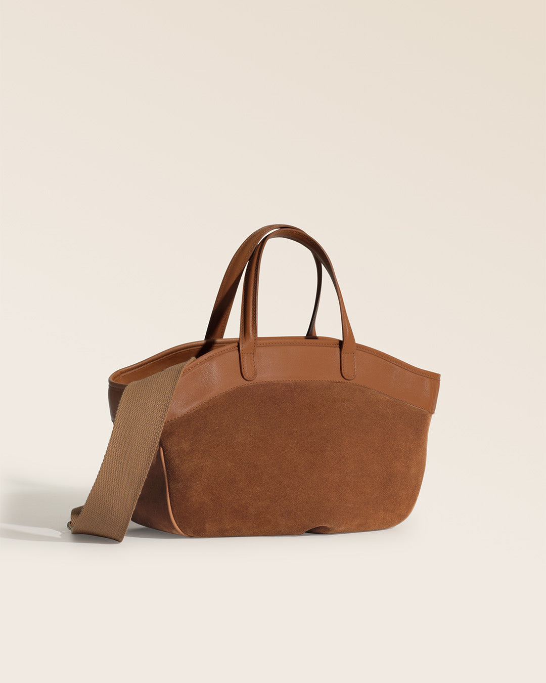 Notre sac Sarah Renouard en cuir veau velours noisette et cuir vintage camel, avec sa bandoulière coton, vu de quart en studio.