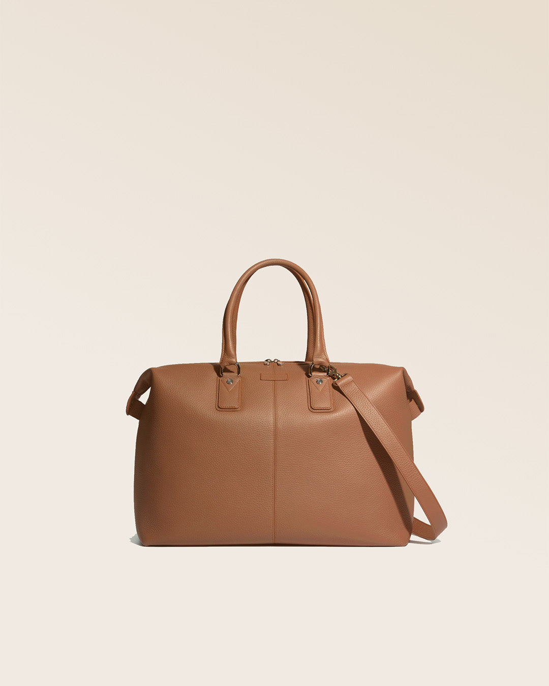 Notre sac de voyage Escapade petit modèle en cuir façon vigogne fauve vu de face en studio.