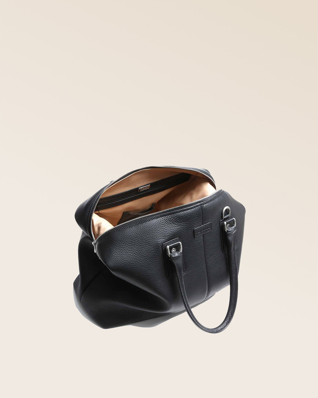 Notre sac de voyage Escapade petit modèle en cuir façon vigogne noir vu du dessus en studio.