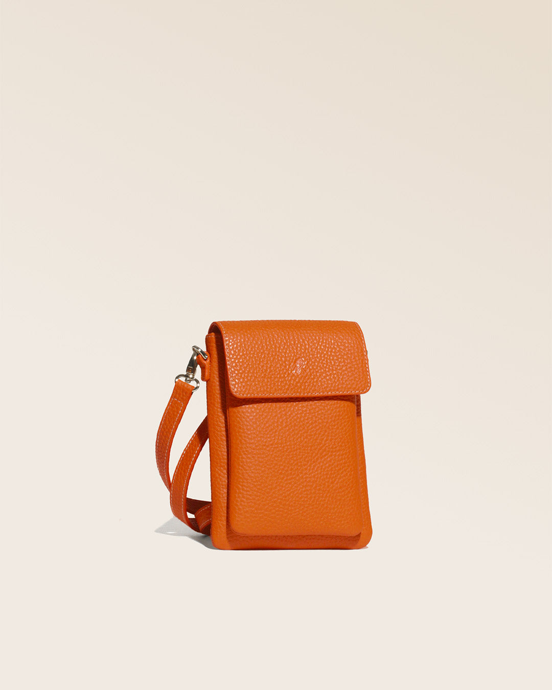 Notre sac pochette Goéland en cuir façon vigogne orange vue de quart en studio.