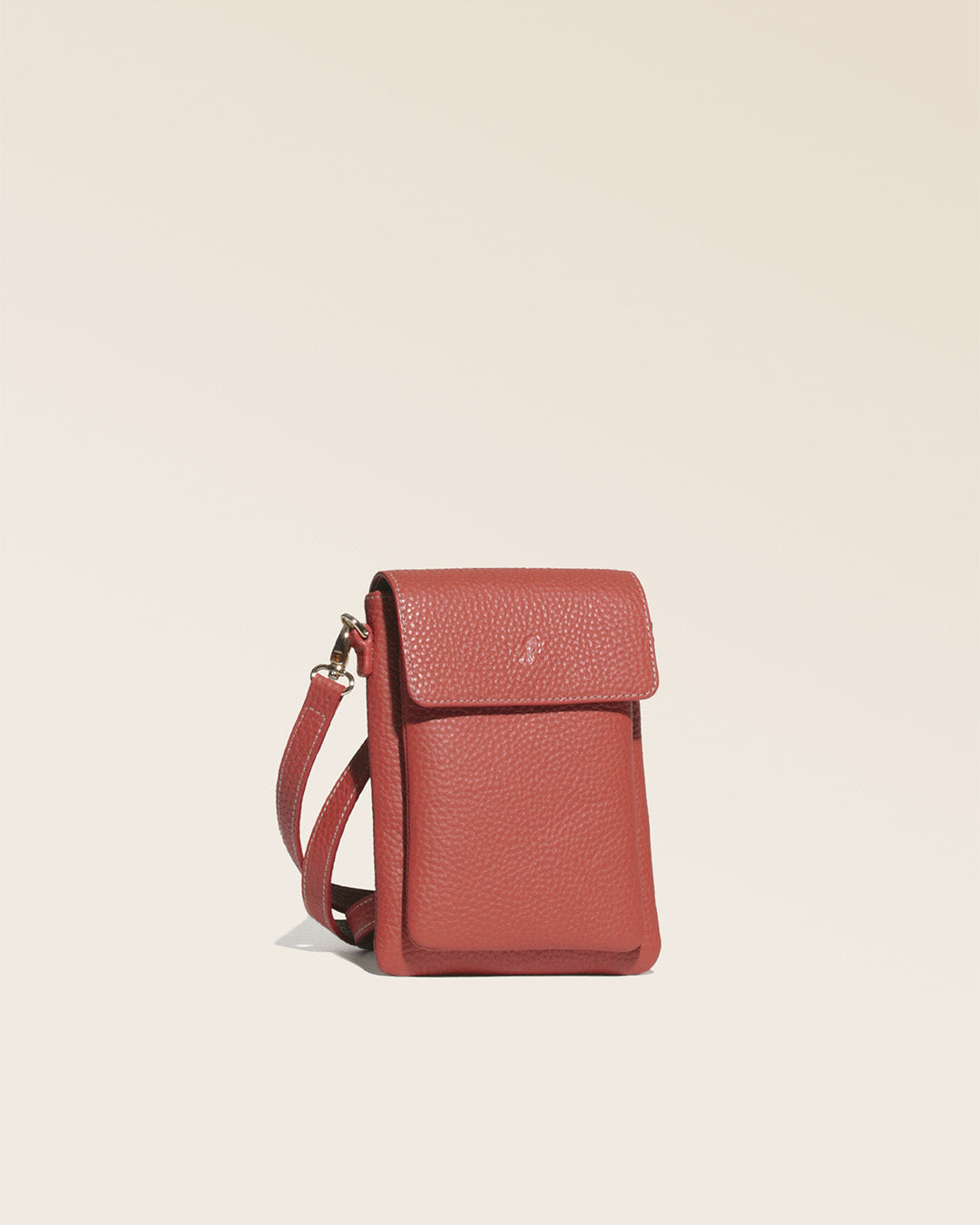 Notre sac pochette Goéland Renouard en cuir façon vigogne terracotta, vue de quart en studio.