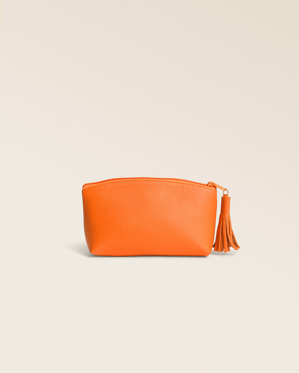 Notre trousse Astrid Renouard en cuir façon vigogne orange, vue de dos en studio.
