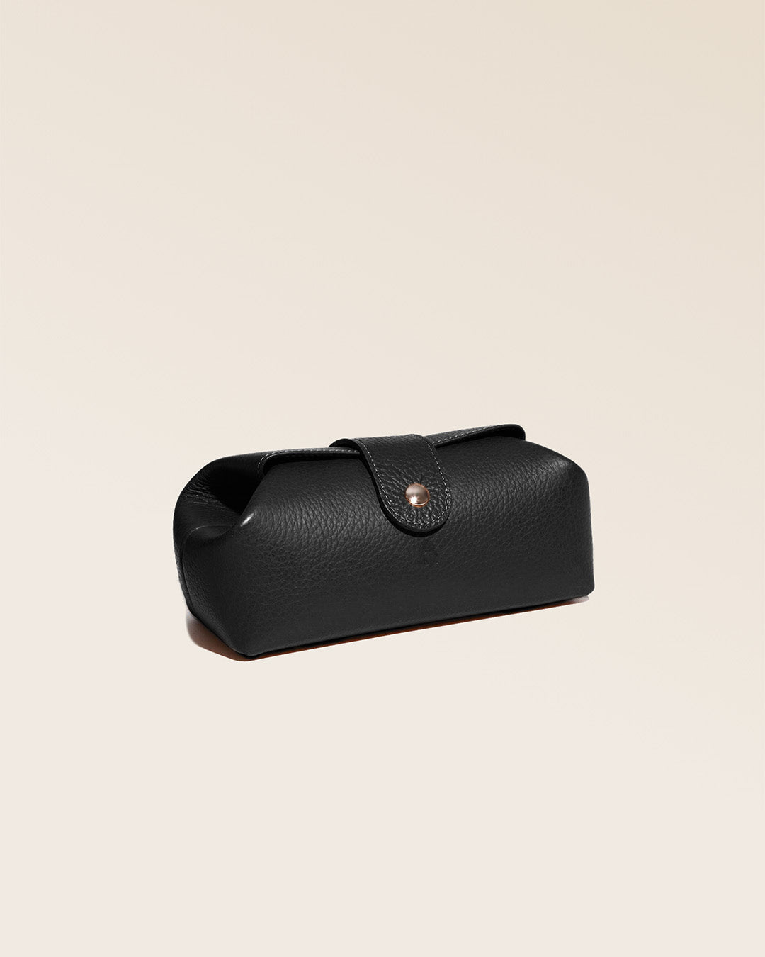 Notre trousse Vecchio Renouard en cuir façon vigogne noir vue de quart en studio.